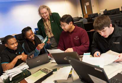 Accounting students and Professor Martha Armstrong work on an audit
