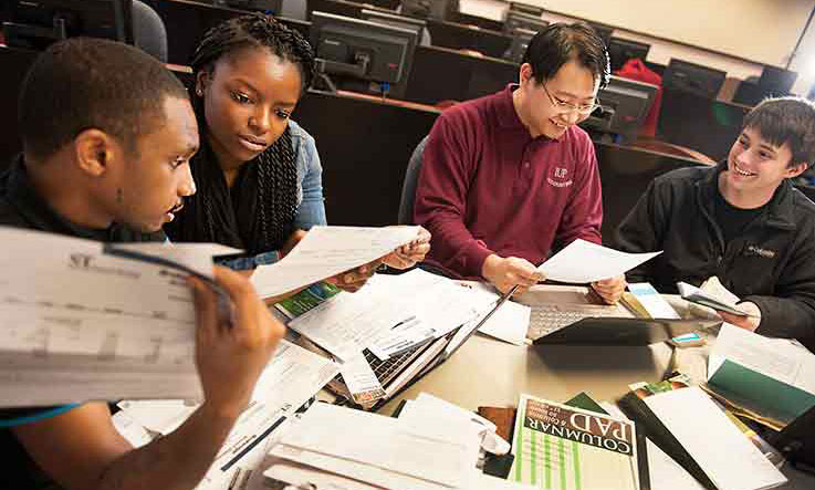 Students study accounting with a professor