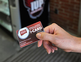 Closeup of someone holding I-Card in front of a vending machine.