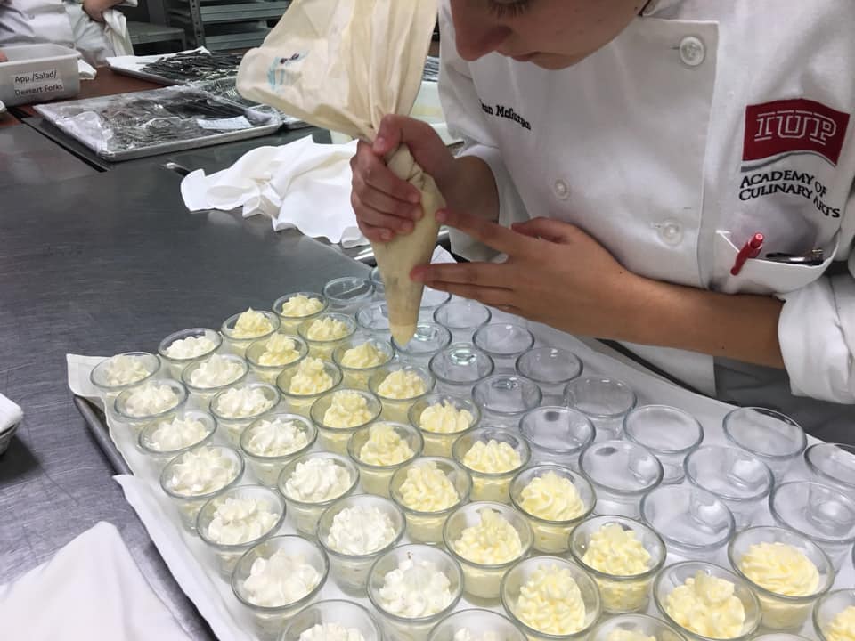 Culinary student piping butter in American Cuisine class