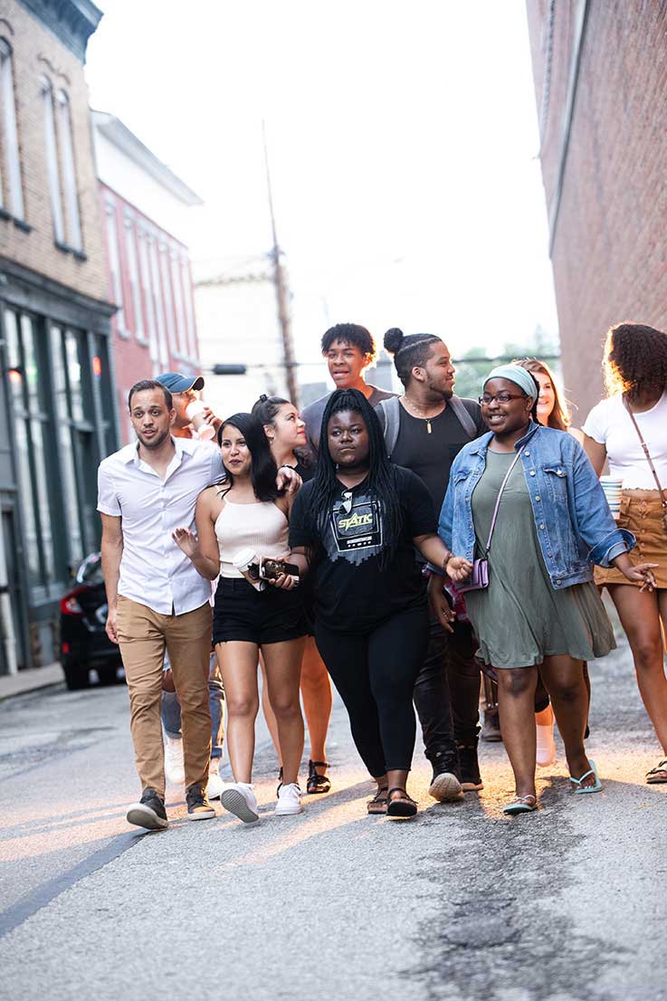 Multicultural students walking on a downtown street 