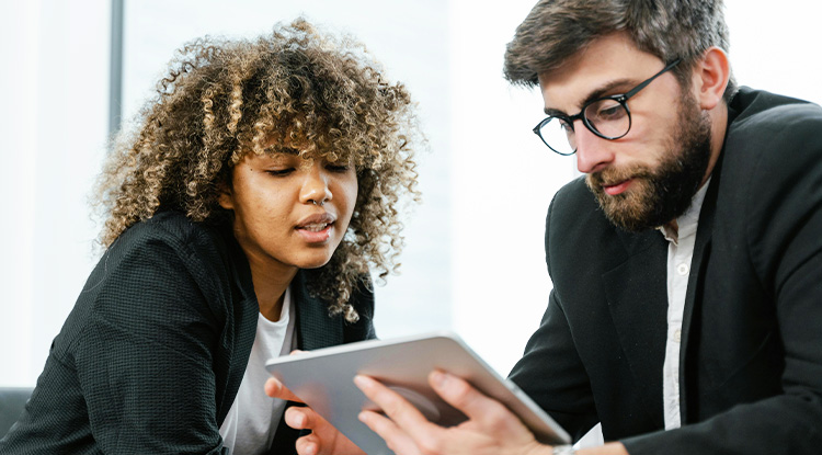 a man and woman examining an electronic tablet