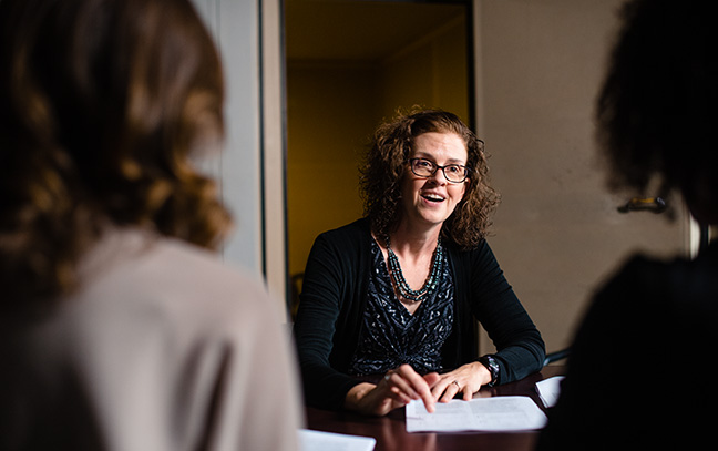 a professor speaks with two students