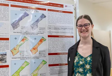 a student standing in front of a research presentation