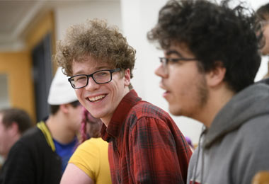 close up of a male student smiling amid a group