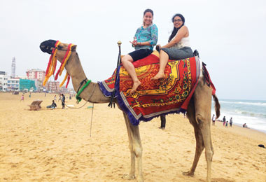 two students riding a camel