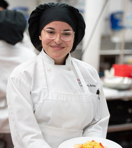 female culinary presenting a dish