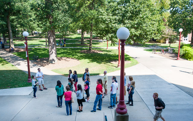 Group of students and families on a tour in the oak grove