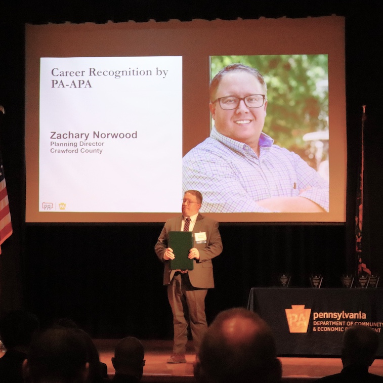 IUP Alum Zachary Norwood on stage receiving award