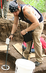 Matt Sagi uses the Bartington magnetic susceptibility loop to collect data for his thesis during an archaeological field school.