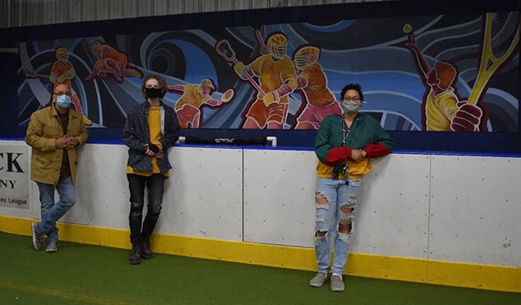 Ivan Fortushniak, Kaycee Morgan, and Heaven Owens looking at the camera in front of their 45-foot mural 