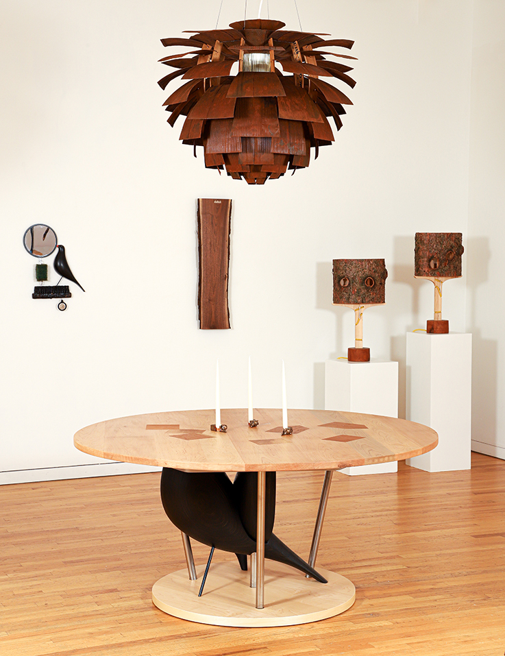 view of art exhibition by Sean Derry with chandelier light and table