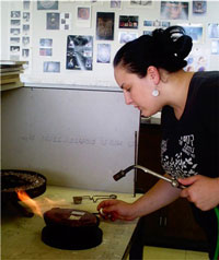 Student working with jewelry and metals