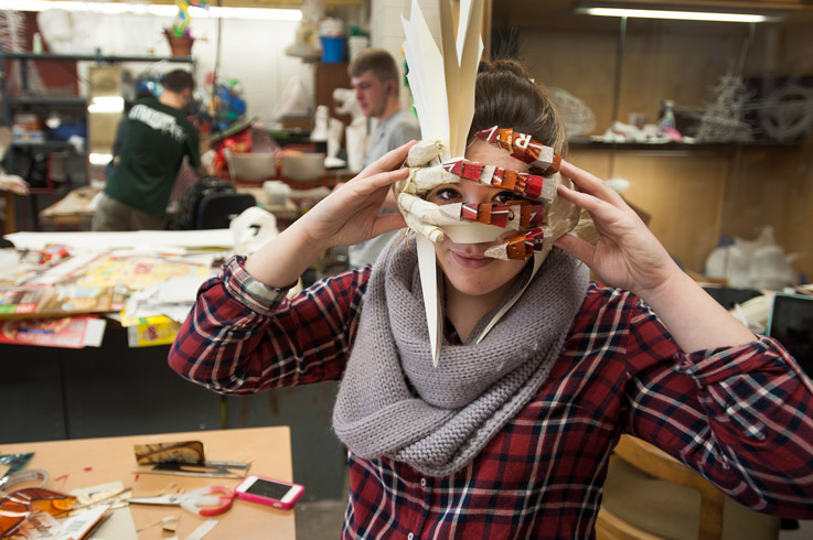 Art student holding the mask she created