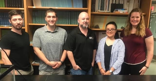 Josiah townsend and the biology students attending the symposium stand together in a lab