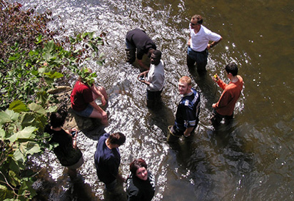 Students in a stream doing field research
