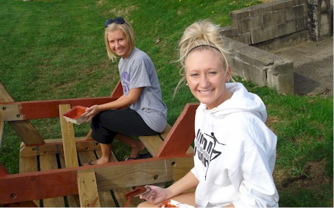 Students painting picnic table