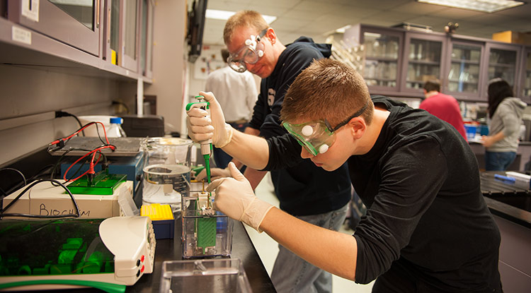 A student and professor work in a lab.