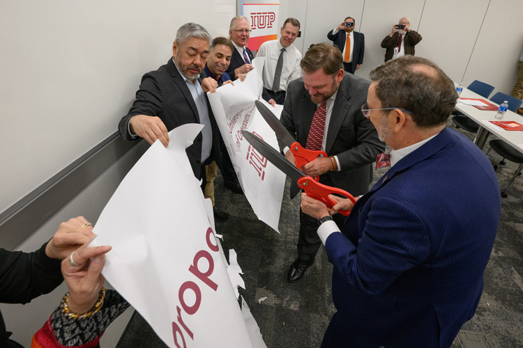 Photo cutting the “proposed” from the banner – from left, IUP President Dr. Michael Driscoll; Sen. Joe Pittman cut “proposed” from the banner with Founding Associate Dean of Pre-Clinical Affairs Dr. Luke Mortensen and Founding Associate Dean of Clinical Affairs and Graduate Education Dr. Ryan Smith, IUP Trustee Chair Sam Smith, COM Director of Admissions and Student Affairs Jamie Murphy