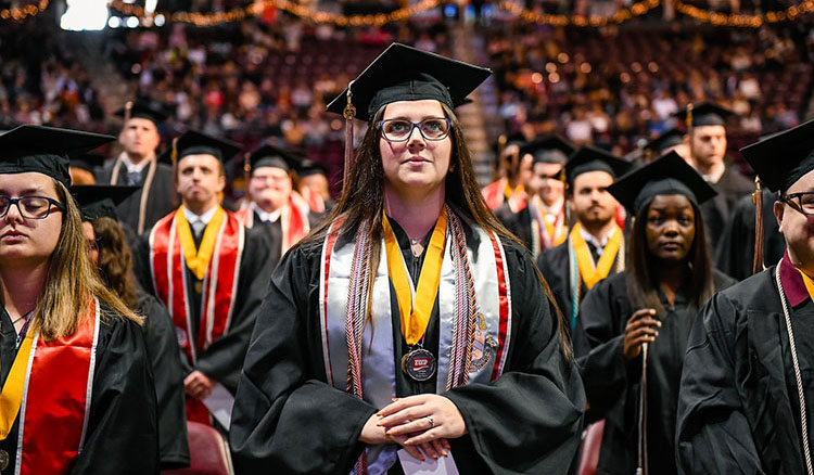 Graduating students standing and waiting during the Commencement ceremony