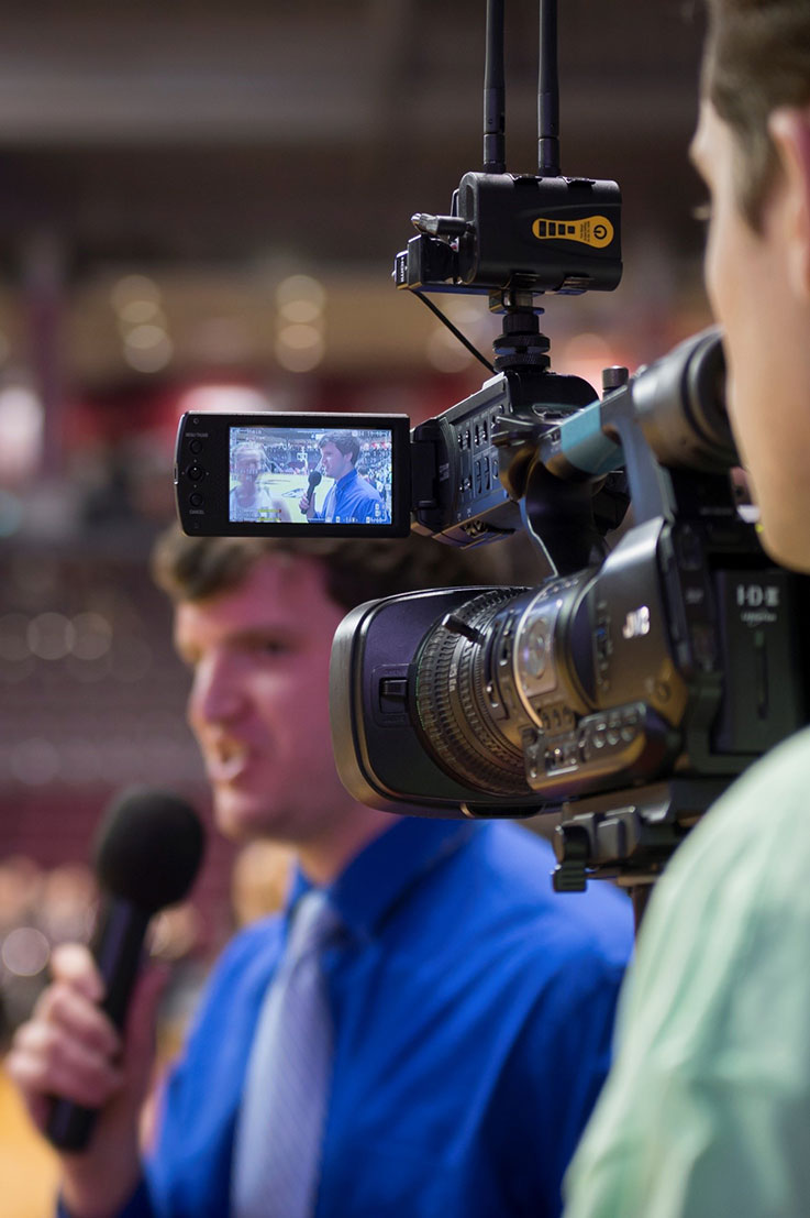 Student reporter on camera at a sporting event
