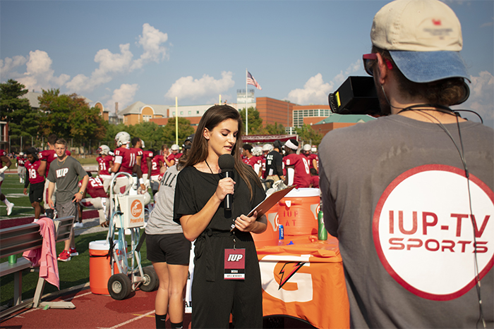 IUP-TV reporter at an IUP football game