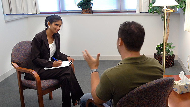A student practices interviewing a client
