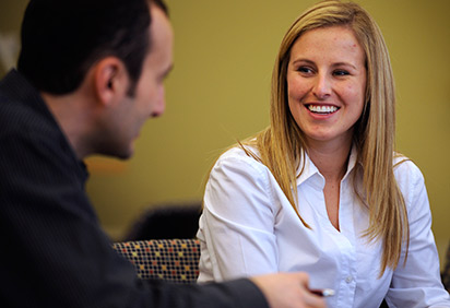 Two students talk in a classroom