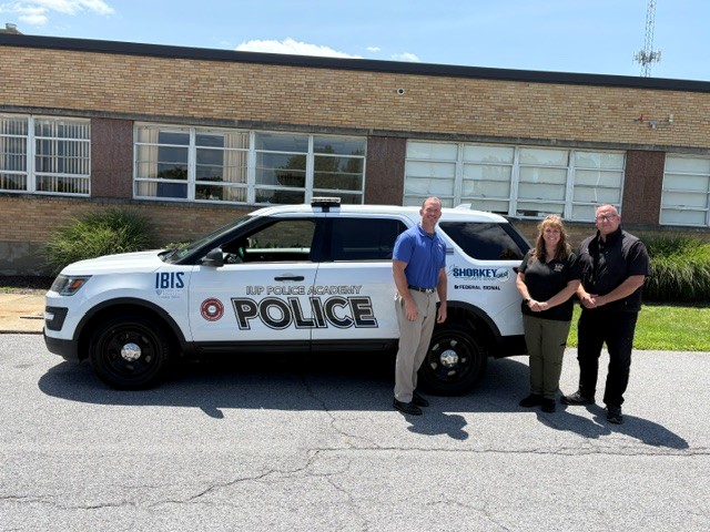 Greg Boss, Marcia Cole, and Sean Boyle with donated retired police vehicle
