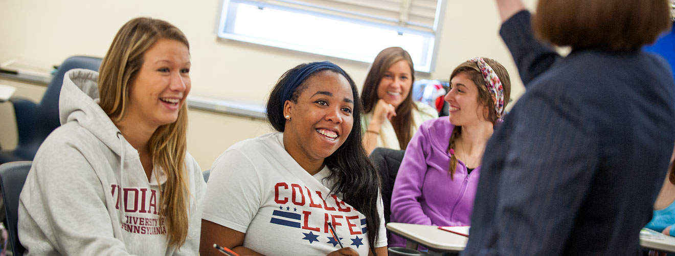 group of students listening to a professor teach in the classroom