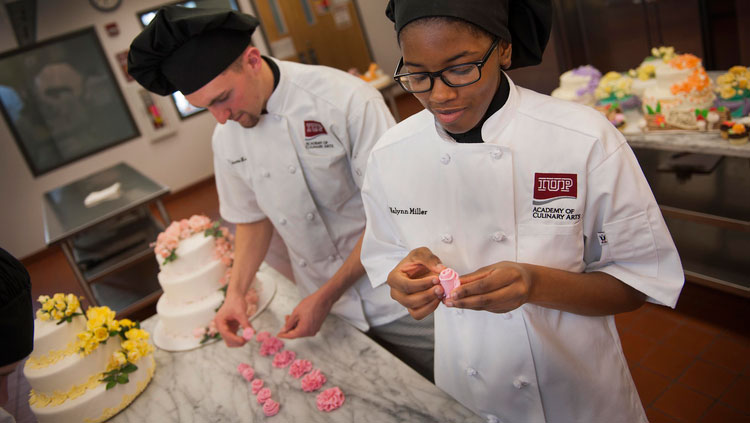 Baking students decorating wedding cakes