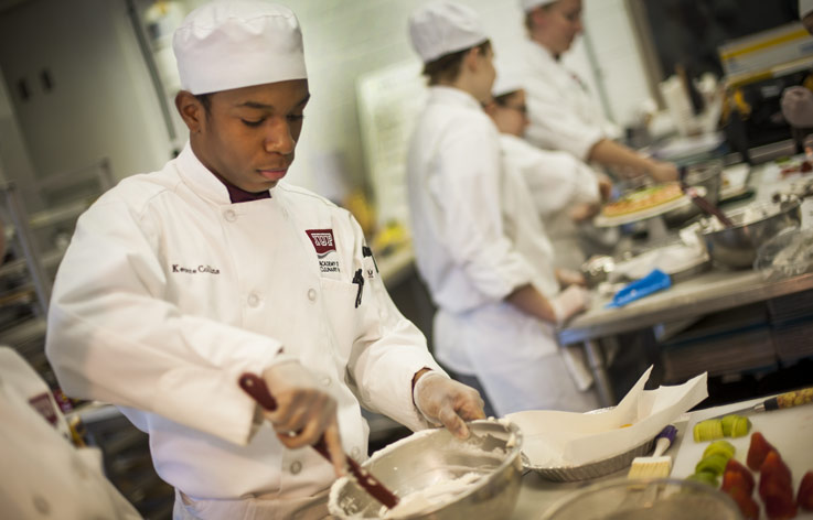 student working in the culinary academy kitchen