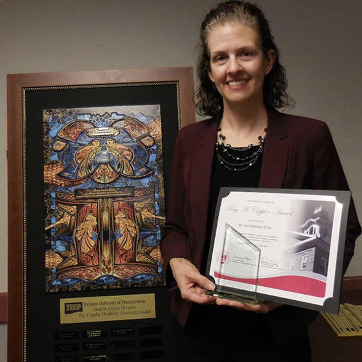 Dr. Lisa Hammett Price posing with Coppler Award plaque