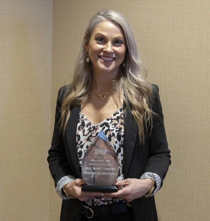Danielle Benson holding Impact Award