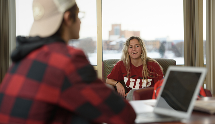 Two students working together at a laptop.