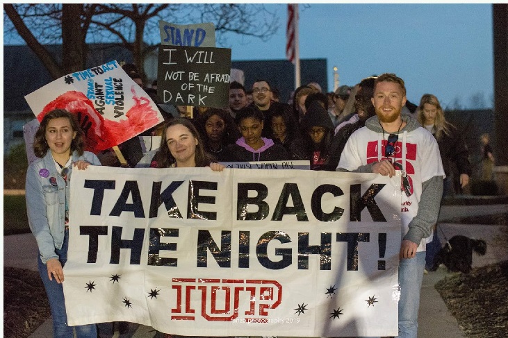 Students carrying banner through the Oak Grove at the 2019 Take Back the Night