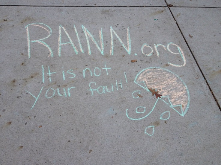 chalk on the side walk that says rainn.org