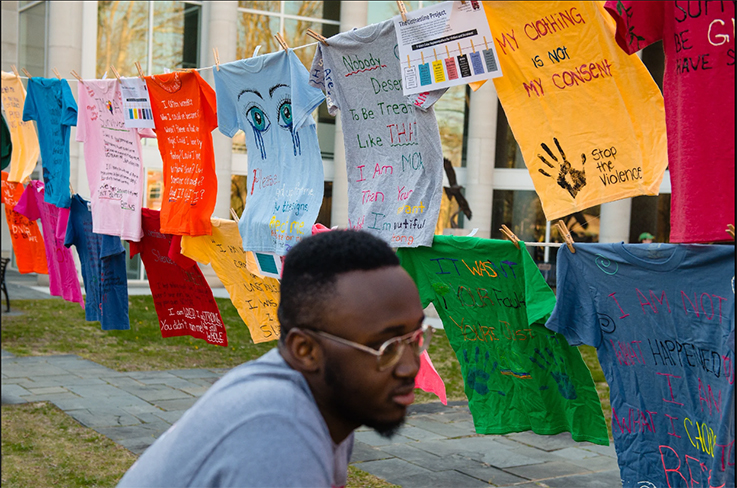 person viewing the t-shirts on the clothesline project
