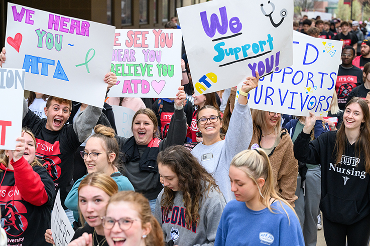 image from the take back the night march with students holding signs