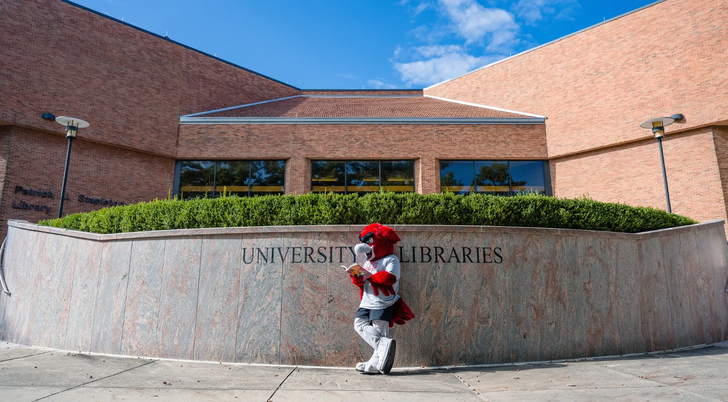Norm reading a book in front of the library