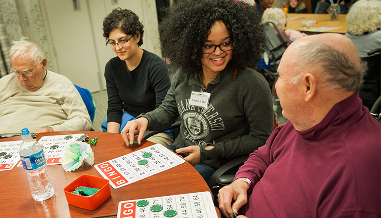 Honors college student playing bingo with two other persons