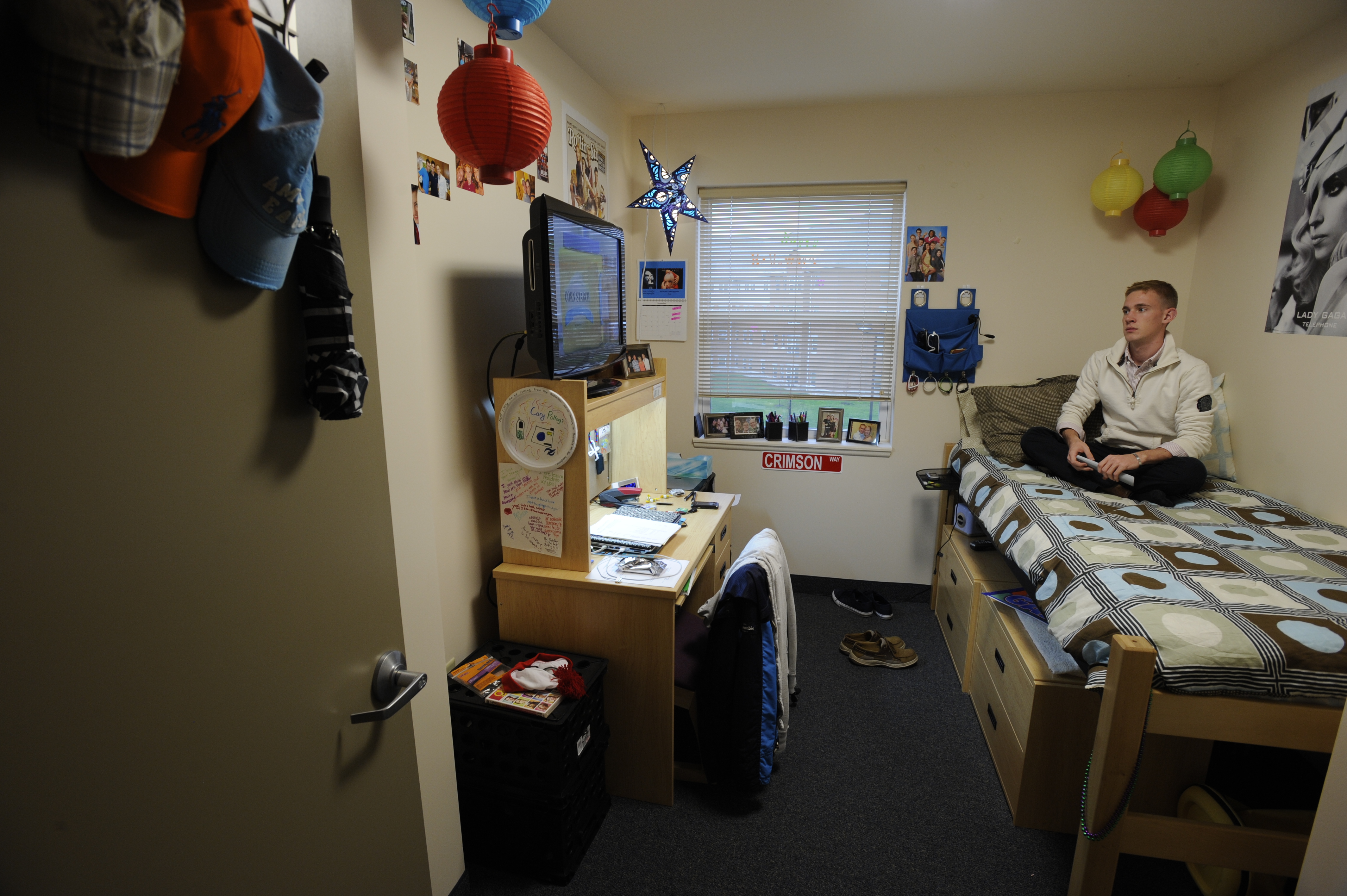 An IUP student relaxes in his room while watching tv. 