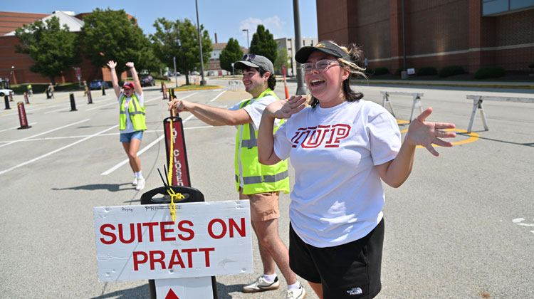 sign saying suites on pratt with helpers guiding and waving 