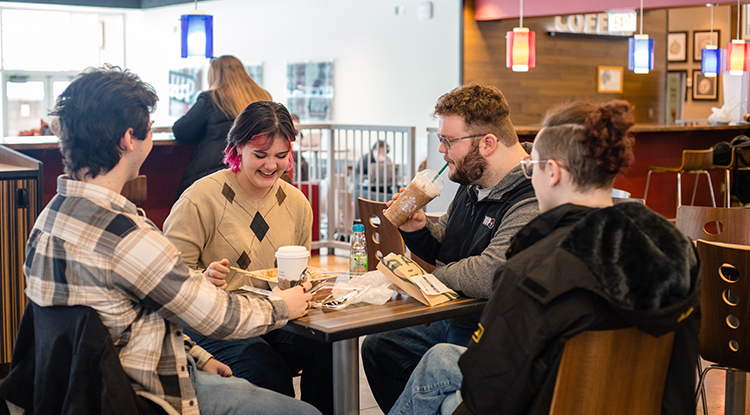 Four students dining at a table inside the Crimson Cafe.