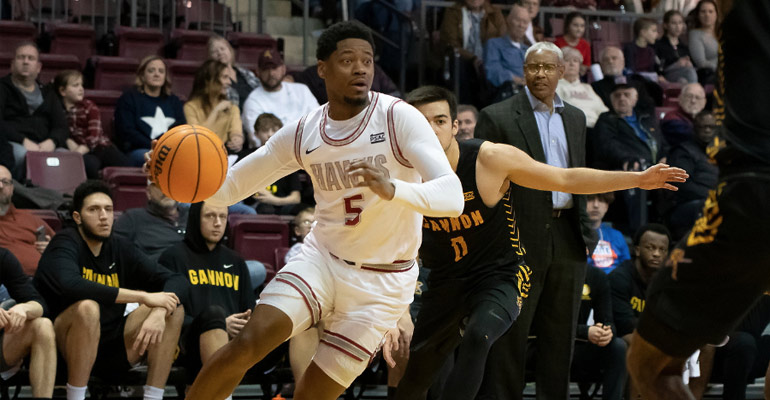 An IUP basketball player dribbling the ball down the court