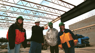 Four people inspect an industrial installation