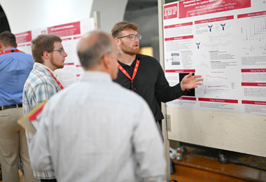 a student presenting his poster on research at USOAR event