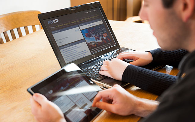 A student uses an iPad and a laptop