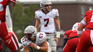 a crimson hawk football player lining up under center