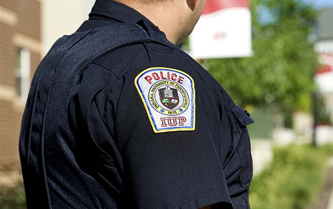 a close up of a university police officers shoulder showing his uniform and IUP Police shoulder patch
